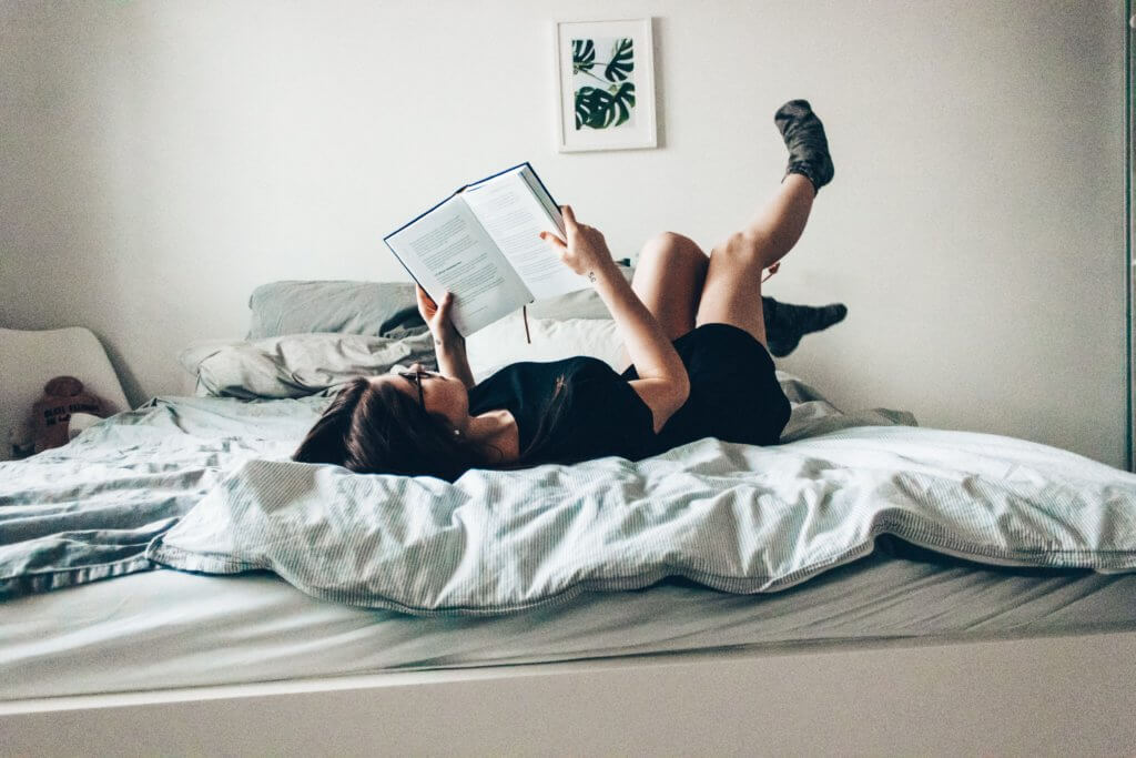 ベッドで寝ながら読書する人